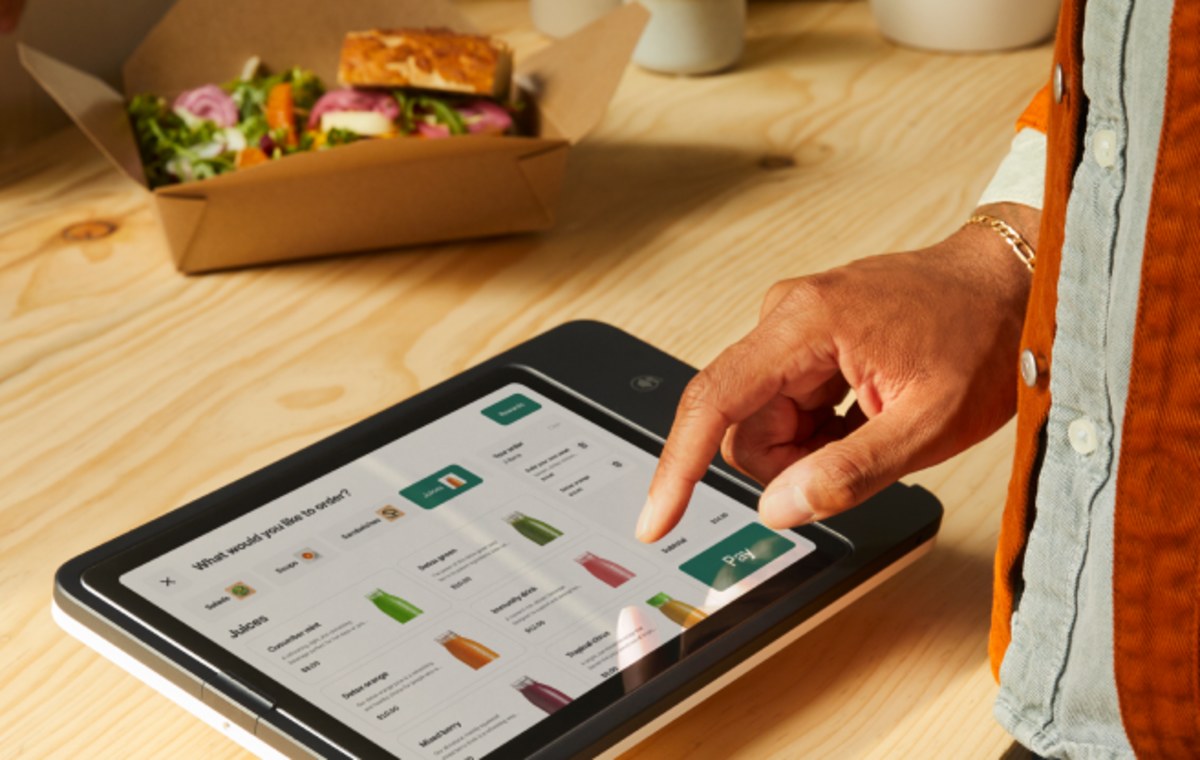A customer placing their own order on a countertop Square Kiosk
