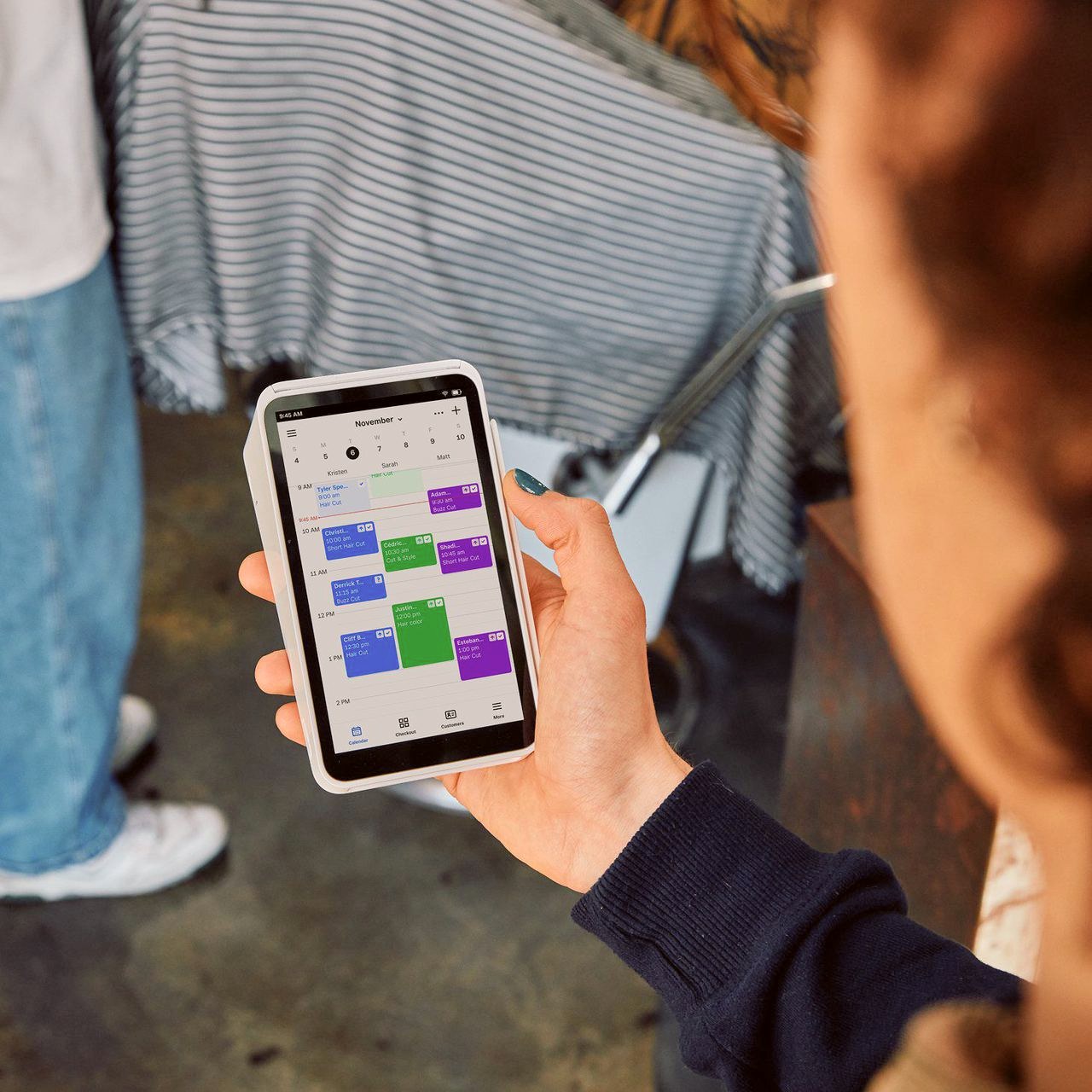 A stylist checking the day's appointment calendar on a Square Handheld