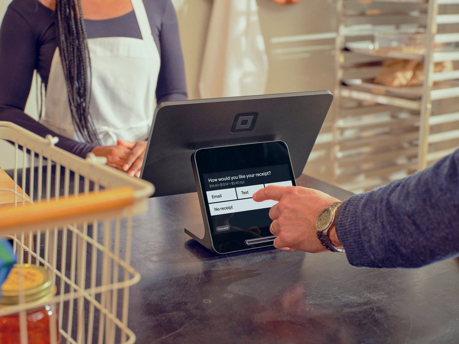 A customer picks a receipt option on the customer display of a Square Register (2nd generation) at a bakery counter